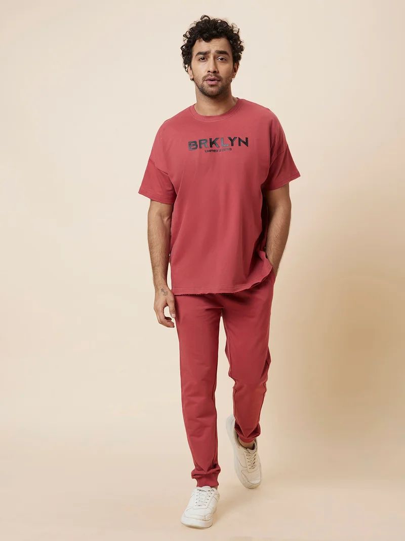 جلو باص طقم رياضي رجالي من جلوبس بلون الصدأ مع تي شيرت مطبوع وبنطلون جوجر